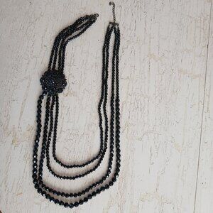 Black 4 Strand Bead Necklace 38 in L with 2 in. Brooch-like Bead Cluster